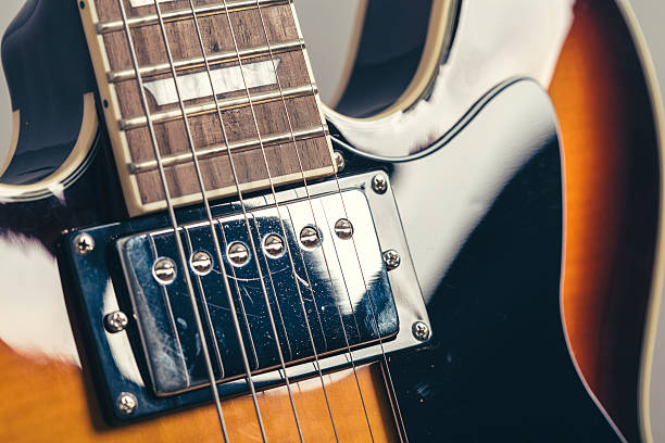 istock Chrome electric pick up on a dark sunburst electric guitar 584485410
