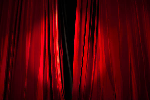 istock Spotlight on the Stage Curtain about to Open 584487590