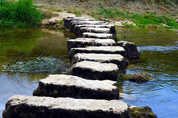 primer plano de escalinatos que cruzan un pequeño río - sand footprint track following fotografías e imágenes de stock