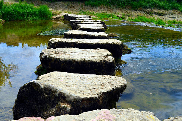 istock closeup of stepstones crossing a small river 584490194
