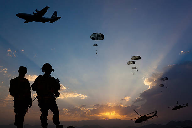 Military Mission at dusk ATTENTION FOR INSPECTOR: This is a composite photo and the date of model releases are different from the date of image. Please consider this. Paratroopers jumping from the plane and military helicopters leave behind soldiers for a night mission. helicopter photos stock pictures, royalty-free photos & images