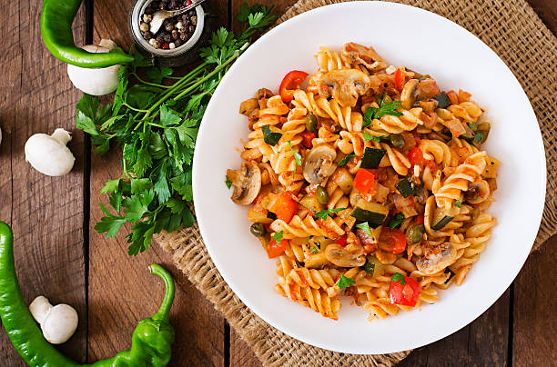 vegetarian vegetable pasta fusilli with zucchini, mushrooms and capers - pasta directly above fusilli food imagens e fotografias de stock