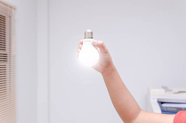 istock Woman hand holding LED bulb 584497416