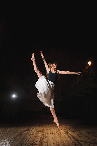 istock Young brunette dancer girl in split jump 584498022