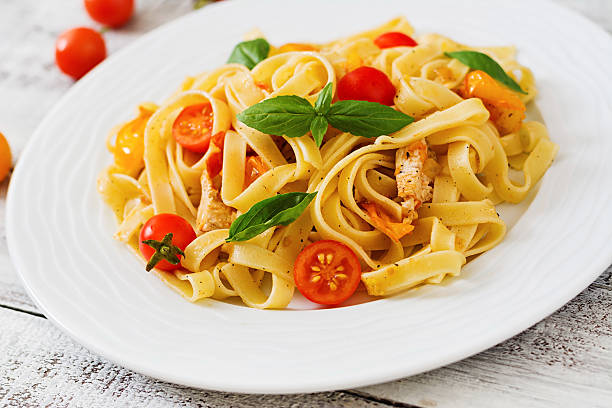 istock Fettuccine pasta in tomato sauce with chicken, tomatoes 584499588
