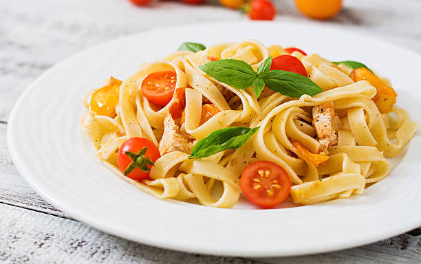 istock Fettuccine pasta in tomato sauce with chicken, tomatoes 584499778