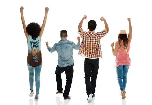 Rear view of four friends cheering