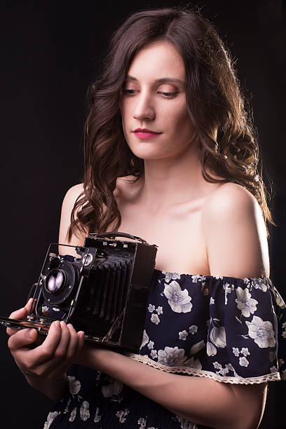 istock Young woman photographer with old camera 584501572