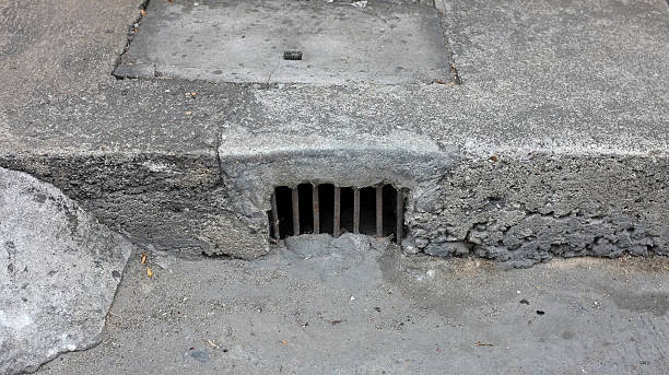 istock Drain gutter in the road, next to pavement, showing curb 584503074