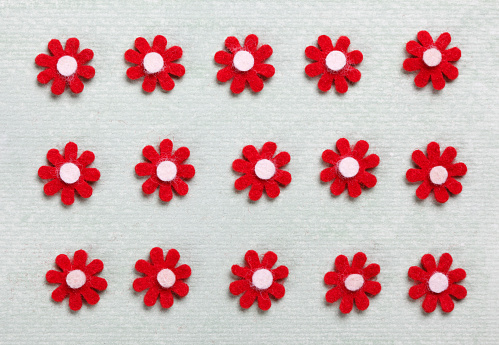 Red felt flowers on painted background