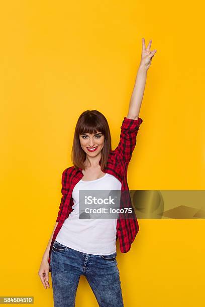 Smiling Woman Showing Victory Hand Sign Stock Photo - Download Image Now - Colored Background, People, Adult