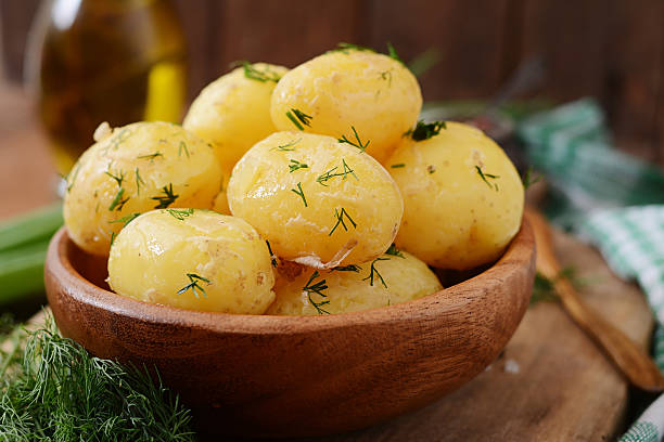 patatas nuevas hervidas sazonadas con eneldo y mantequilla - hervido fotografías e imágenes de stock