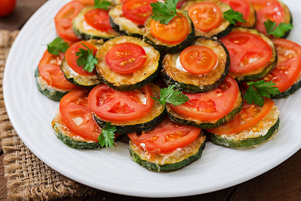 istock Dish with a snack of fried zucchini with tomatoes 584507590