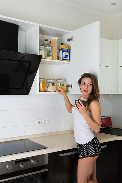Woman  preparing a breakfast at her kitchen in the morning