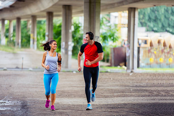 istock Fit attractive couple running outdoors together. 584566416