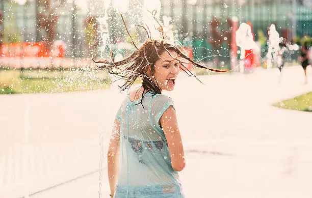 Girl having fun in a water fountain.