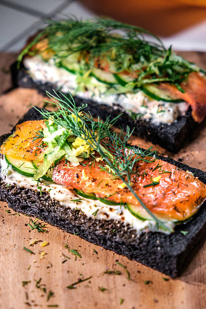 istock Charcoal Bread Smoked Salmon Sandwiches on wood board 584567834