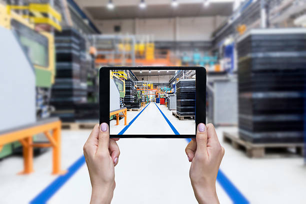 istock Female hands showing factory on tablet 584569412