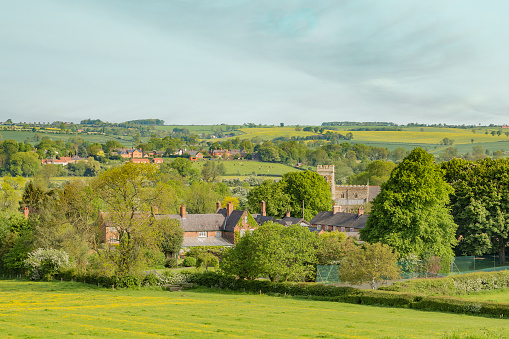 Aerial photograph over country village, church and  homes surrounded by farm pasture and crops.