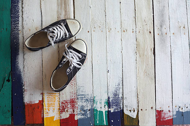 istock female sneaker on grunge wooden panels 584571216