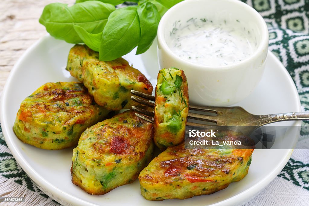 Healthy vegetarian potato patties Healthy vegetarian potato patties with carrots, broccoli, bell pepper, green peas and onions with sour cream sauce with dill and Basil. Selective focus Broccoli Stock Photo