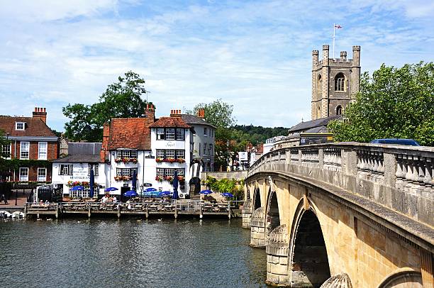 Henley-on-Thames, Oxfordshire - January 9, 2022: the River Thames is very wide at Henley-on-Thames, and this beautiful five-arch, stone bridge was constructed in 1786 to span it.  The bridge was designed by General Henry Conway of Park Place, and his daughter, the sculptress Anne Damer, carved the heads on the bridge's keystones: Tamesis facing downstream, and Isis upstream.  Henley is famous for rowing, including the annual Henley Royal Regatta.  It is a popular tourist destination.
