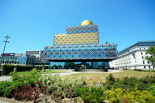 Birmingham, United Kingdom - June 6, 2016: Front view of the Library of Birmingham in Centenary Square with people passing by, Birmingham, England, UK, Western Europe.