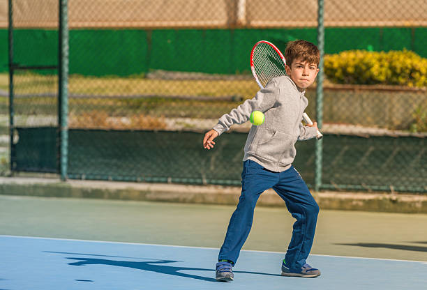 istock young boy play tennis 584574314