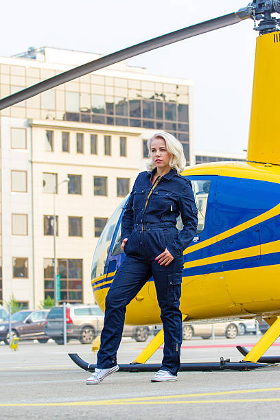 istock Pretty pilot woman on helicopter background 584575858
