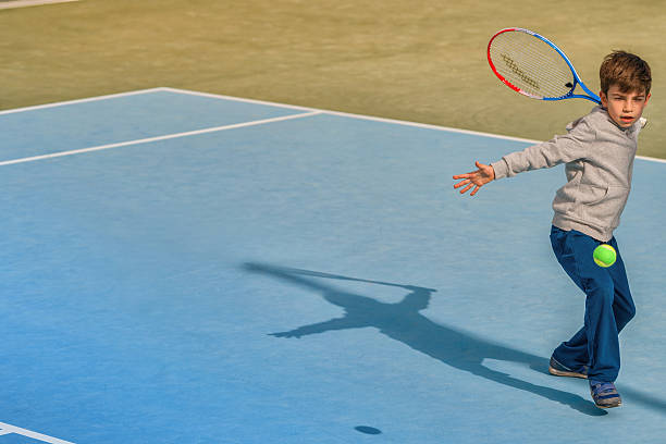 istock young boy play tennis 584576786