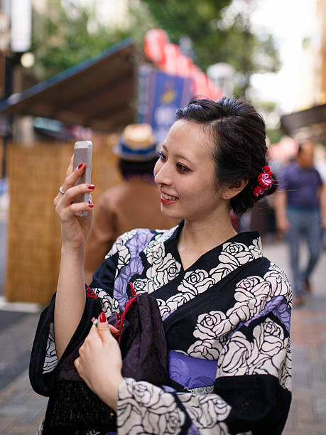 istock Japanese Yukata woman checkning e-mail on smart phone 584577374