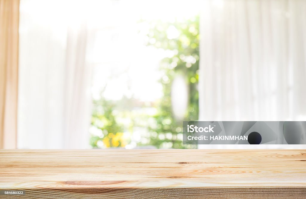 Wood table top on blur curtain window with green garden. Empty of wood table top on blur of curtain window in home with green garden view.For product display summer concept Table Stock Photo