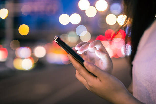 istock using mobile phone in the street at night 584580552