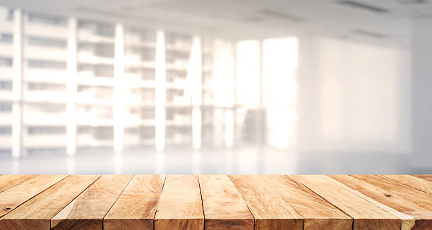 istock Wood table top with blur sunlight on glass window wall 584581494