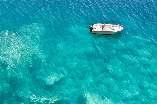 Speedboat anchored in turquoise water bay, high angle view