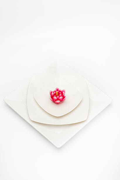 istock Red burning candle on a white plate isolated. 584587542