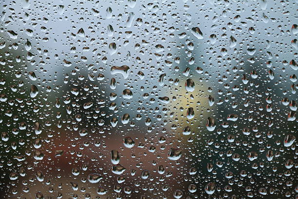 istock Rain drops on window with house and church in background 584588702