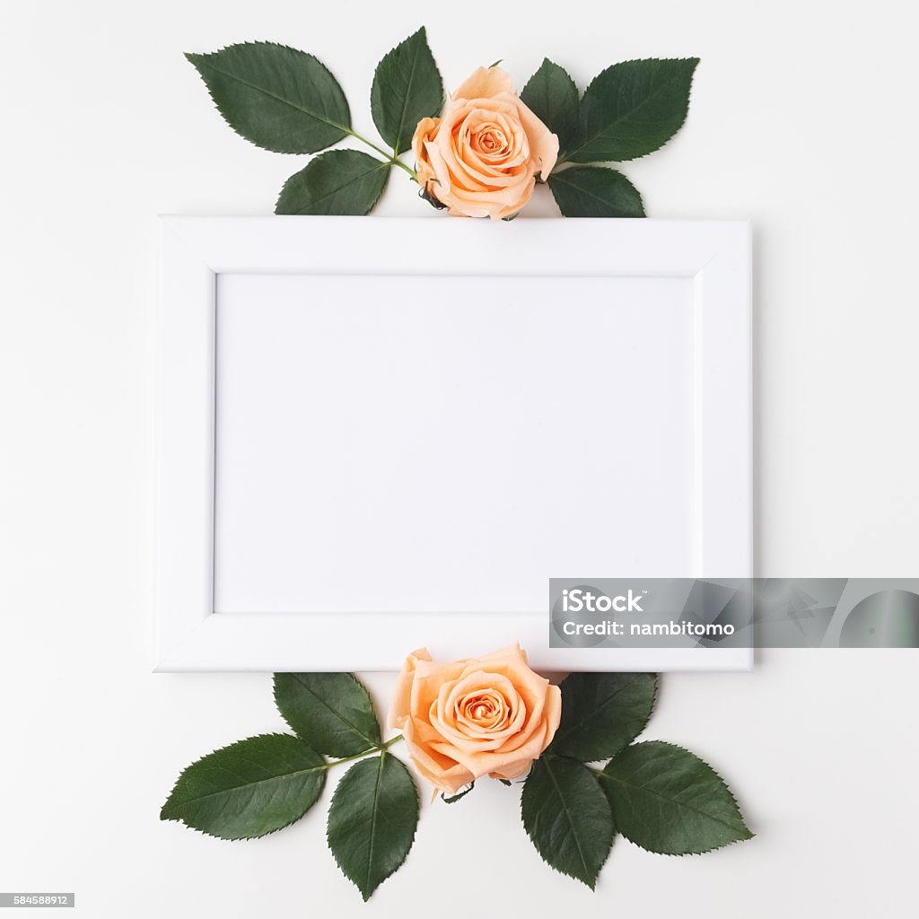 Decorative frame with orange roses and green leaves. Flat lay Decorative frame with orange roses and green leaves. Flat lay. Anniversary Stock Photo