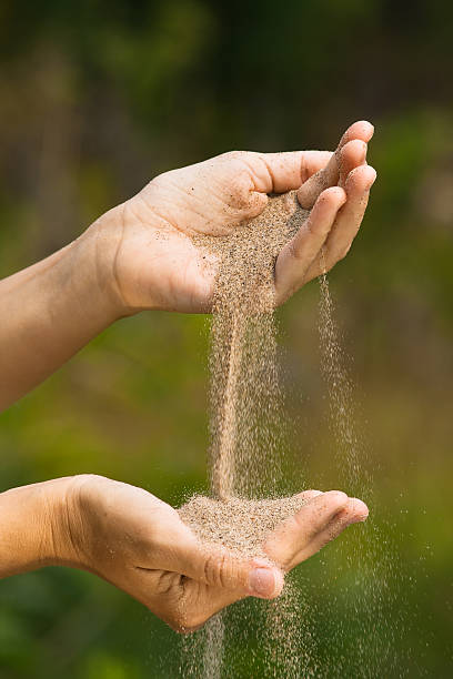 istock sand pouring from one hand to another 584589410