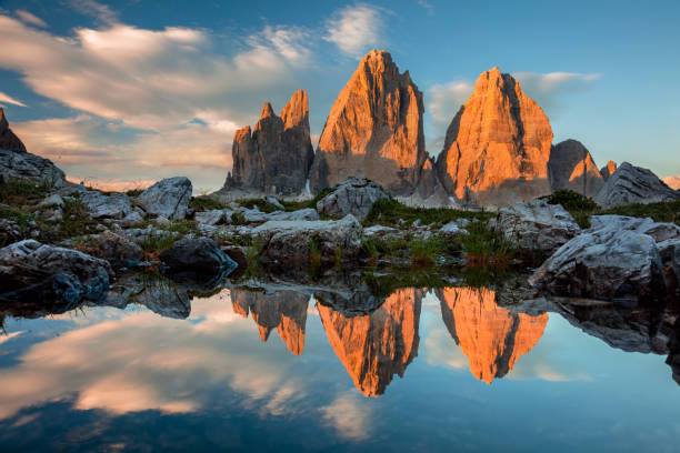 日没時の湖での反射を持つトレ・シメ・ディ・ラバレド - tre cime di lavaredo ストックフォトと画像