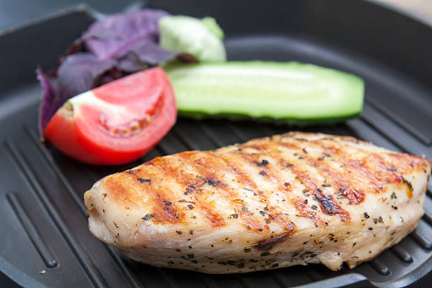 istock Grilled chicken breast with vegetables and herbs 584592170