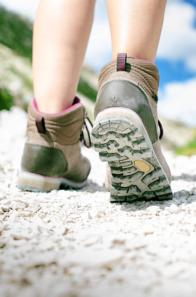 istock Hiking boots on a rocky way and sun 584595884