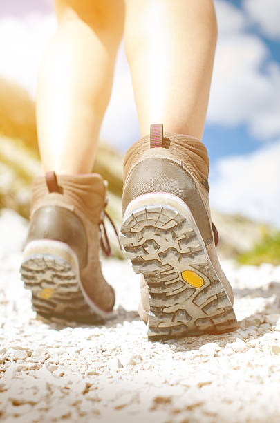 istock Hiking boots on a rocky way and sun 584595962