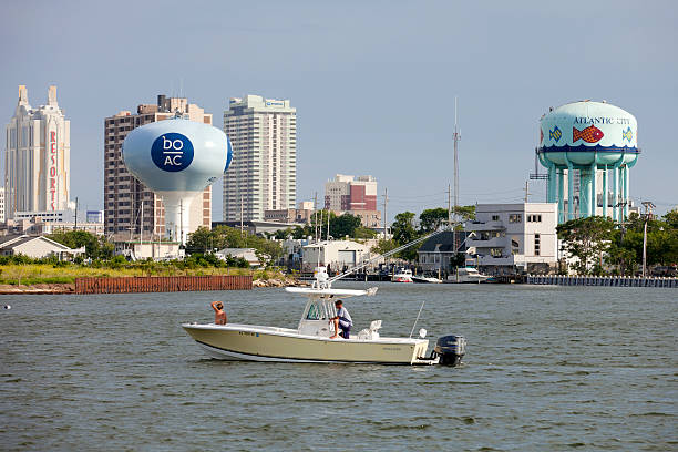 Atlantic City, New Jersey, USA - July 16, 2016: Boating in the back bay with view of the Historic Gardner’s Basin area ofAtlantic City, New Jersey skyline showing the  Resorts  Hotel & Casino and watertowers