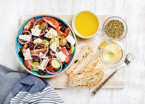 insalata greca con olio d'oliva, pane, spezie e vino bianco - greek culture salad olive feta cheese foto e immagini stock