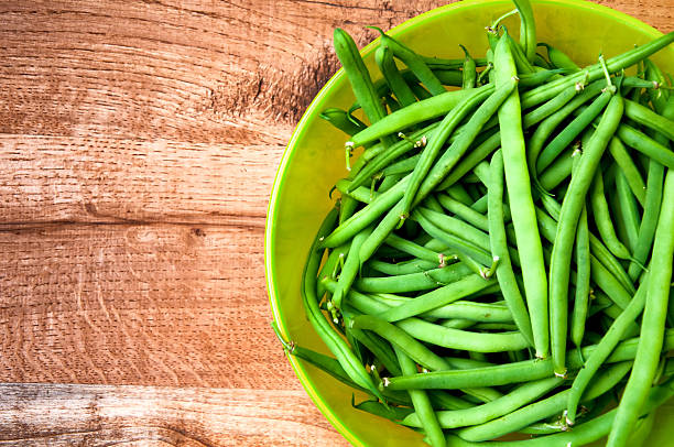istock Fresh green beans in bowl on wooden table 584599750