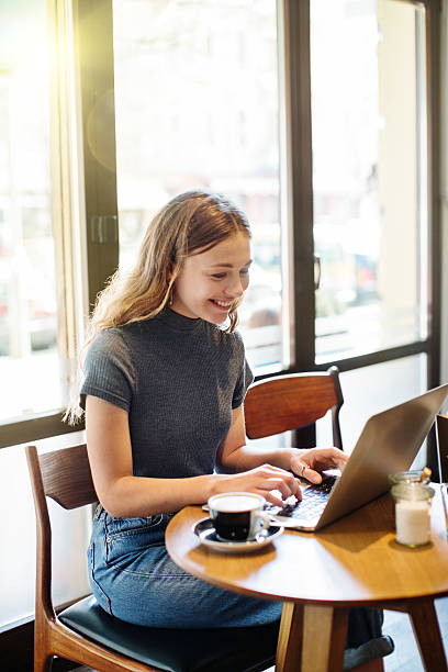 istock Beautiful young woman at a cafe using laptop 584600534