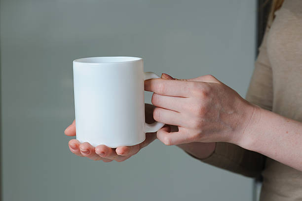 istock White cup in hand of a girl 584601964