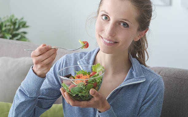 istock Young woman having lunch at home 584603220