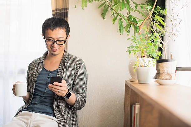 Mid adult man using smartphone at home